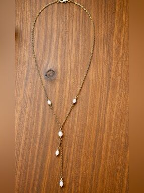 Delicate gold-tone lariat necklace with soft pearl-like bead accents